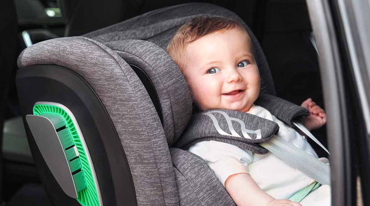 Niño feliz en silla de coche Corazza de Fairgo de color gris